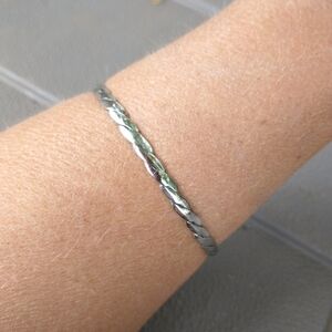 Women's thin silver tone braided bangle bracelet.